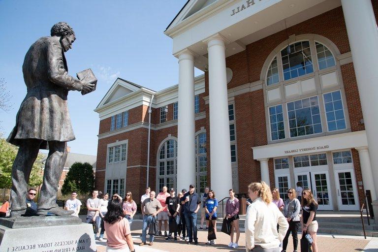 Large group of students 校园 tour in front of Crounse Hall looking at Abraham Lincoln statue